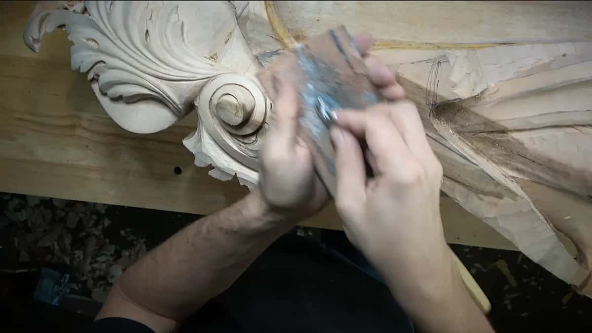 Stropping a gouge on leather held over the bench, paste showing silver gray