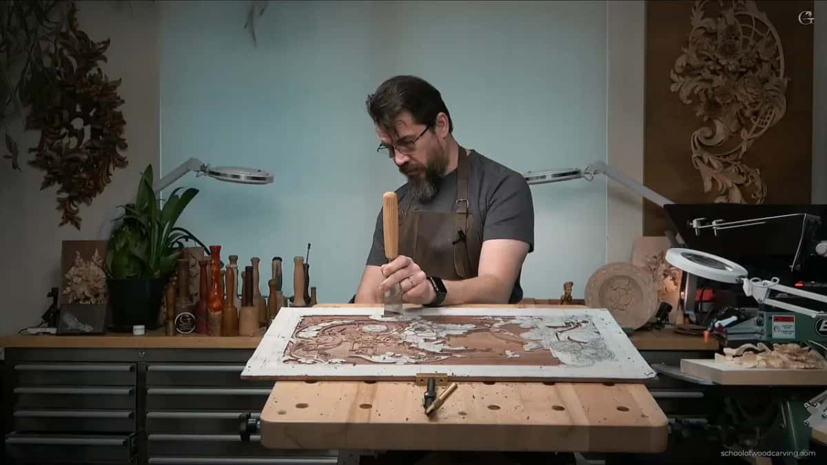 Wide chisel held upright on the panel
