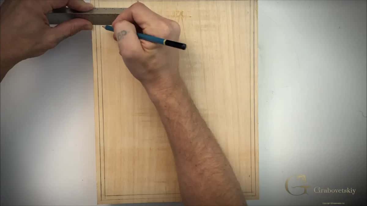 Two lines already run around the blank as the ruler guides the pencil for one more