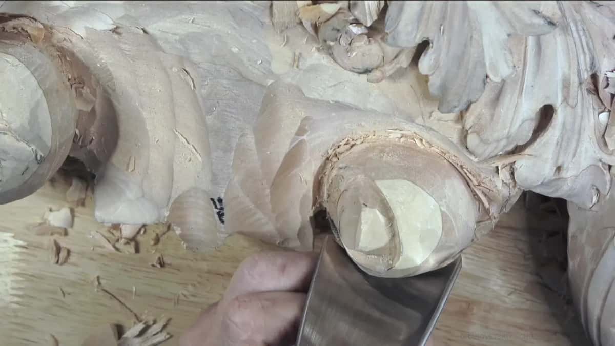 Under the pale end face sits a broad gouge, its shank catching light.