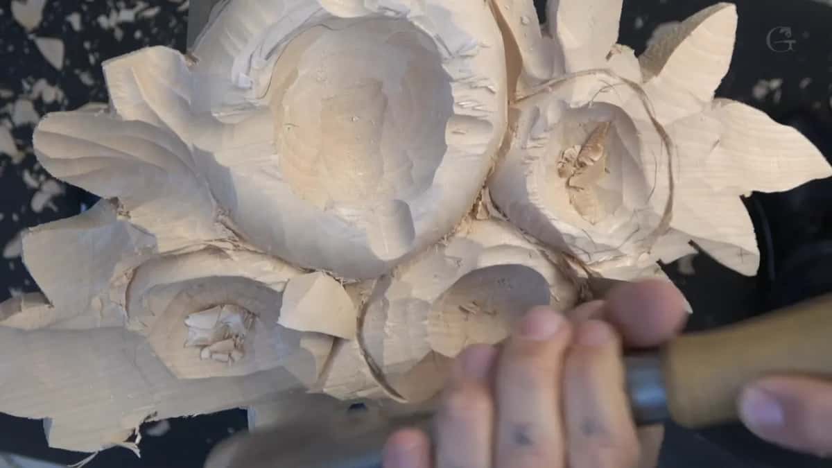 Looking down on all four rings, a wood handle and a hand at the bottom