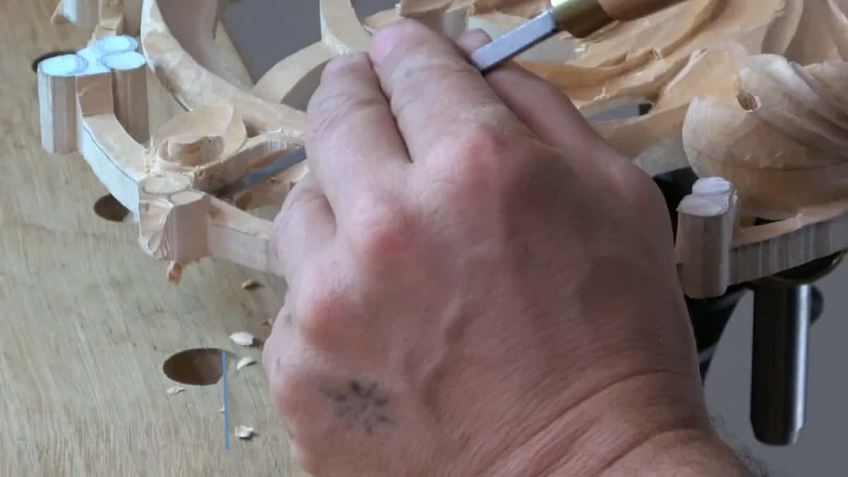 Seen over my knuckles, the panel lies flat on the bench, a narrow blade at one curl