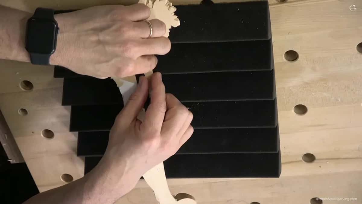 Fingers hold one end against the foam.
