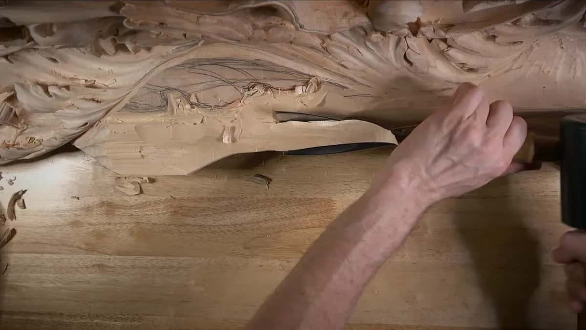 Mallet head at the frame edge beside the working hand