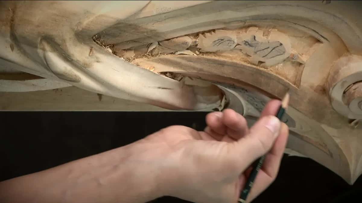 Held low, a pencil waits beside the sketched panel