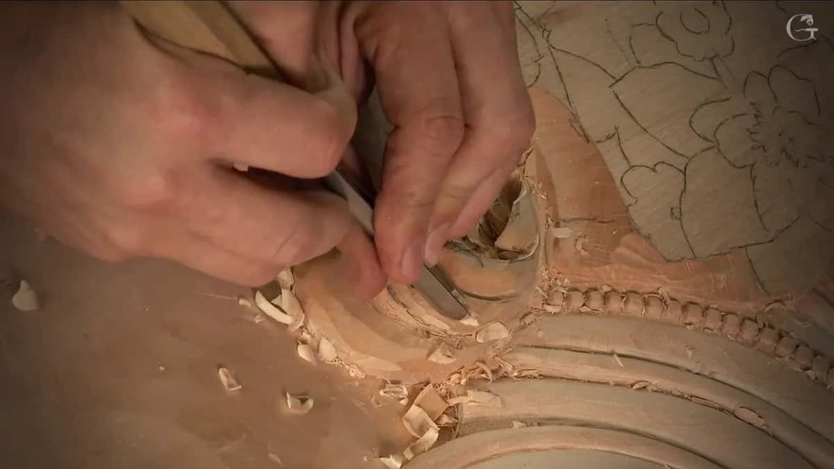 Both hands close in on one small gouge working inside the tightest part of the curl