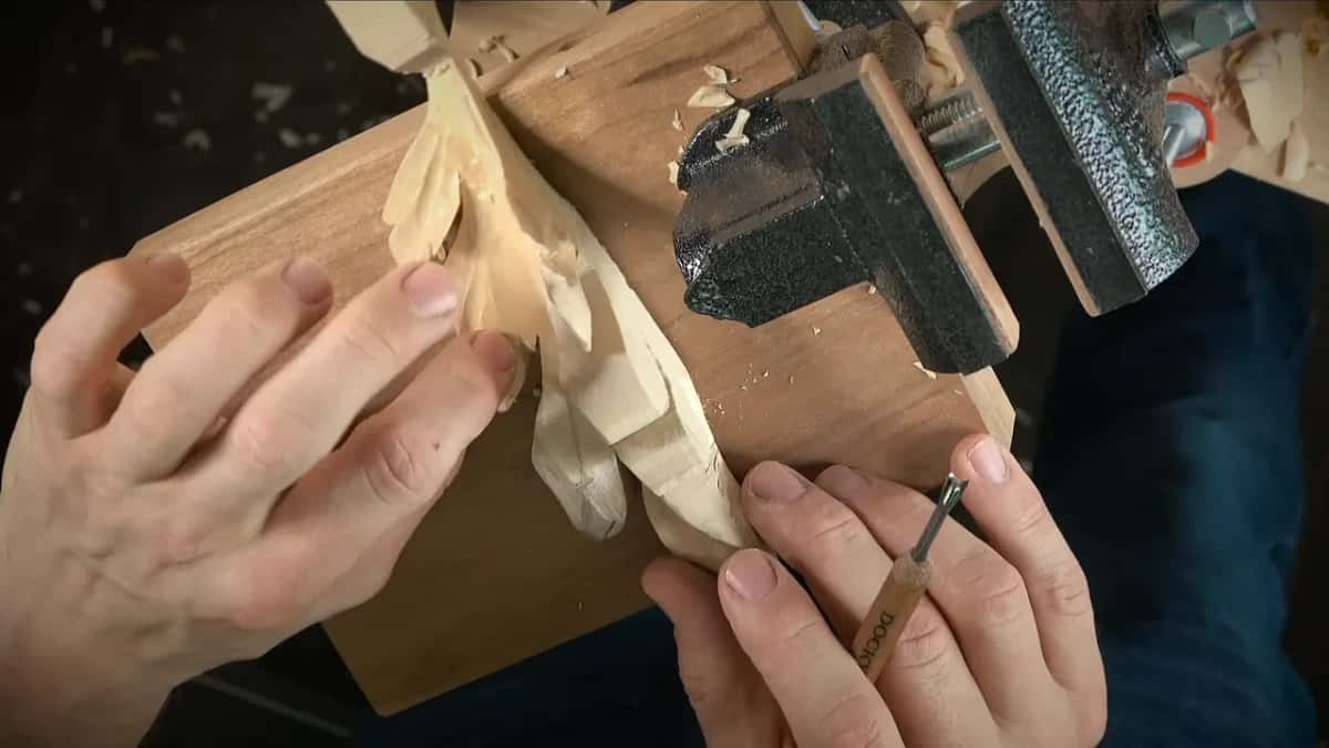 Leaves pressed flat under the fingertips while a slim palm tool works the edge
