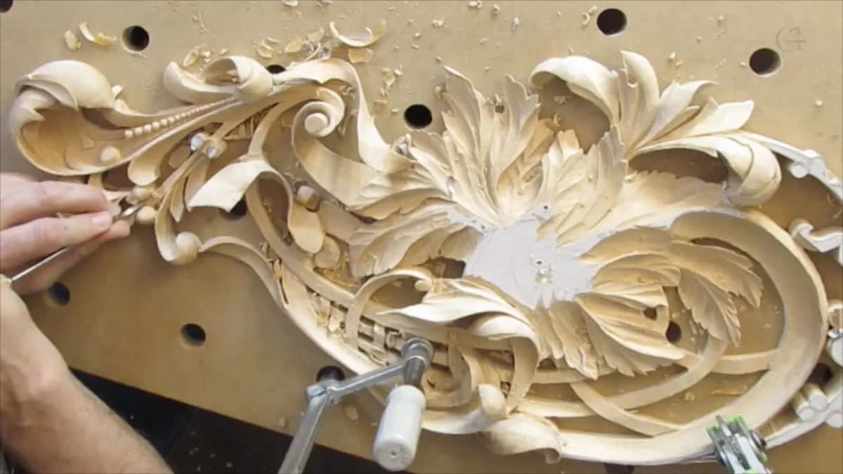Hand at the left edge with a tool, chips still lying on the board above the panel