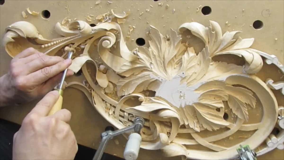 Both hands at the left edge of the panel with a yellow handled tool between them