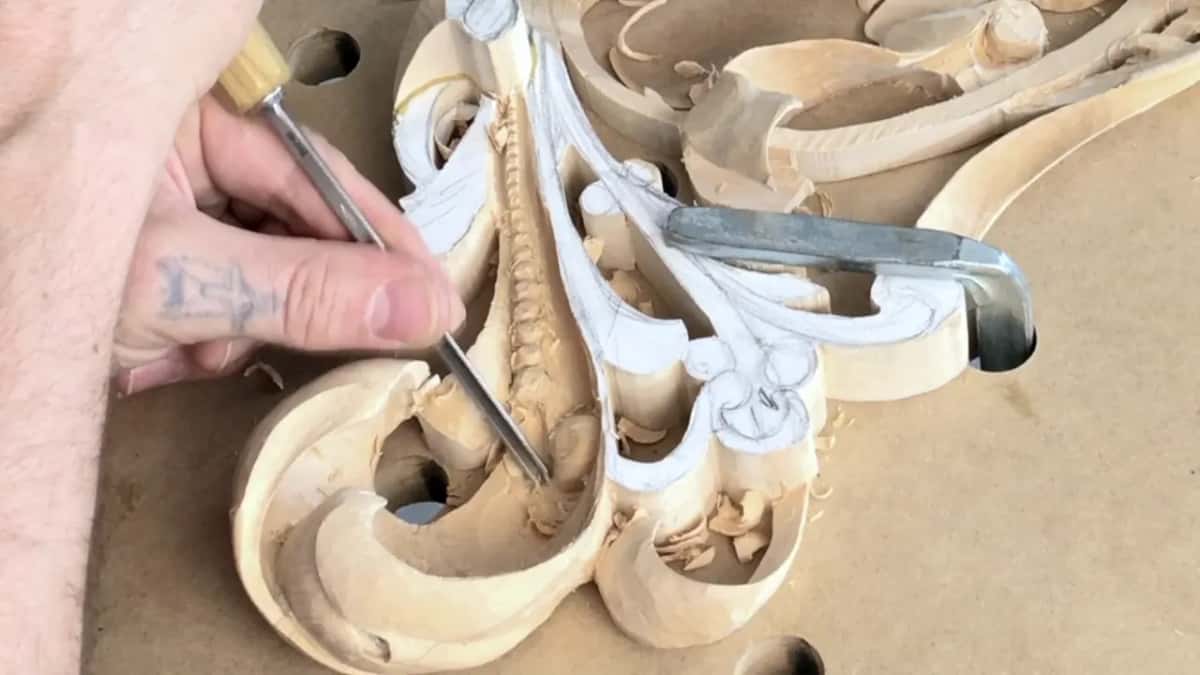 A straight tool reaches into the hollow beside the beaded spine from the upper left