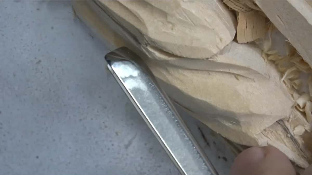 A straight steel shank beside the carved leaf.