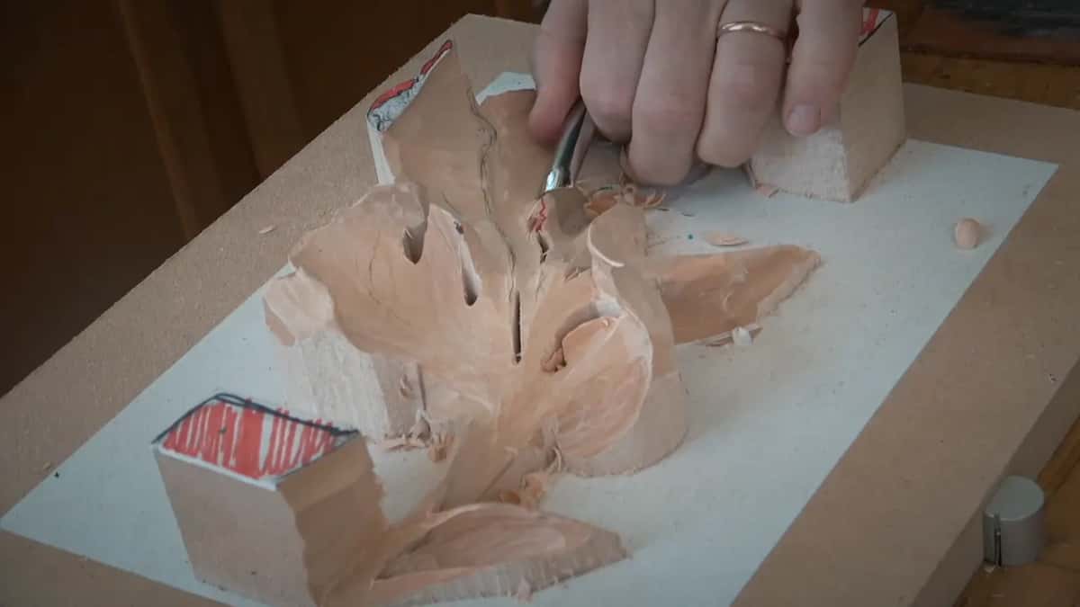 From above, a hand holds a short tool at the center