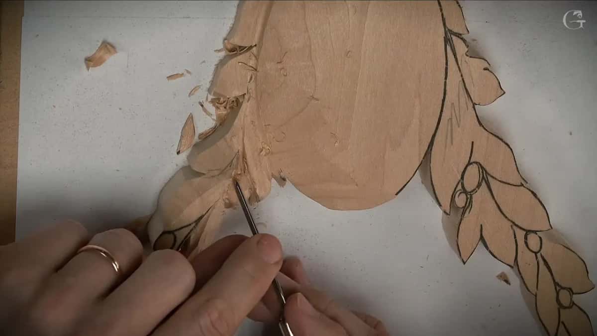 Held at a low angle, a fine gouge works into the left spray just under the oval
