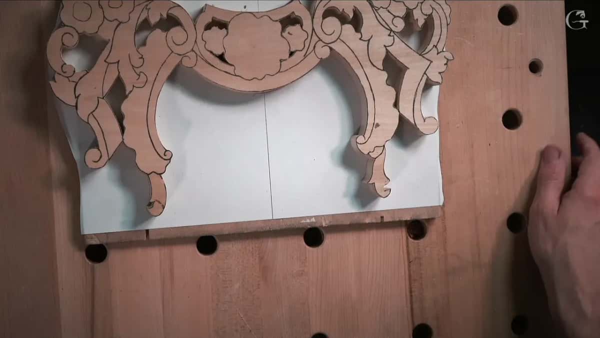 White paper under a sawn scroll blank on a light top with dark holes