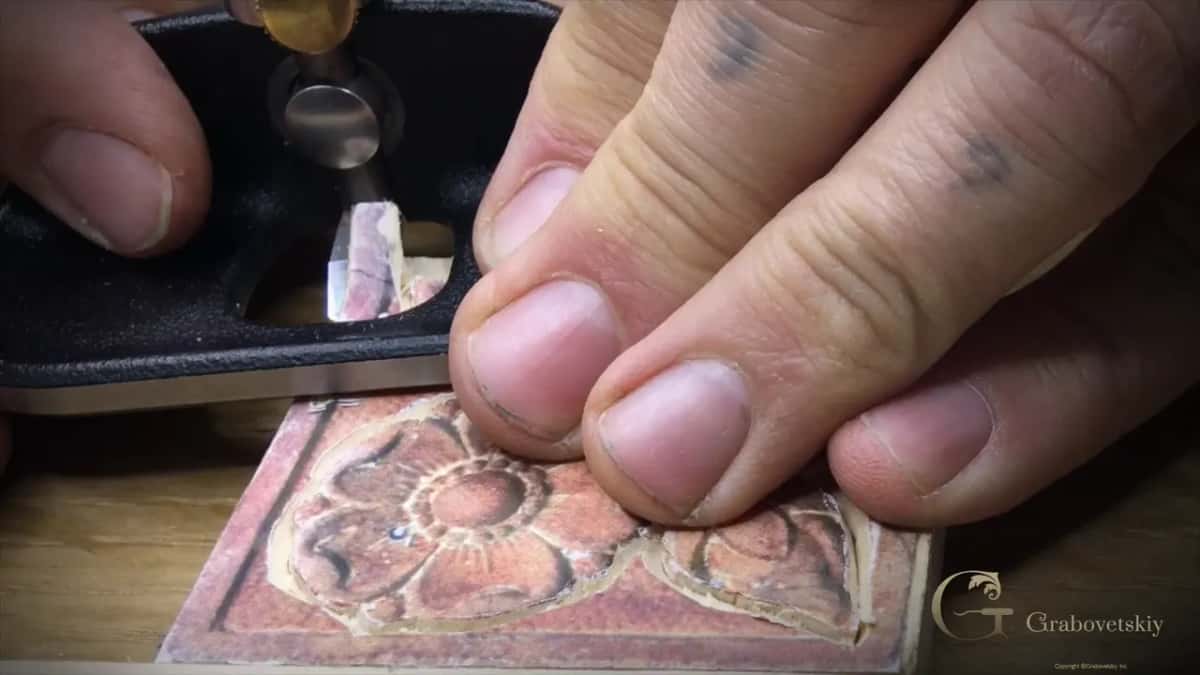 Plane sole over the panel with its blade in view and the paper flower just below.