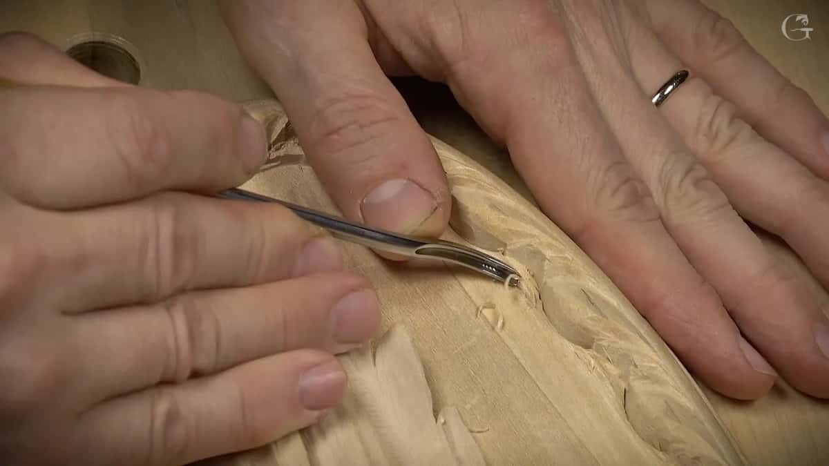 The tool lies almost flat as it slides in under the edge of the border